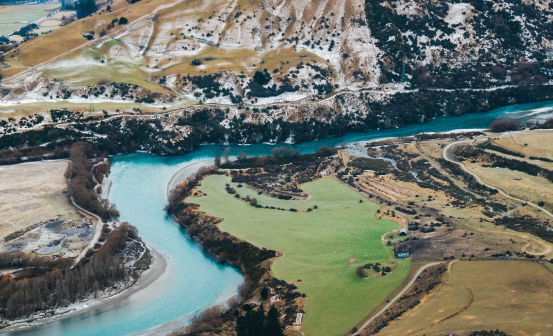 aerial view of green grass field near body of water during daytime